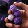 Balles fidget magnétiques texturées : quatre balles violettes texturées tenues en main