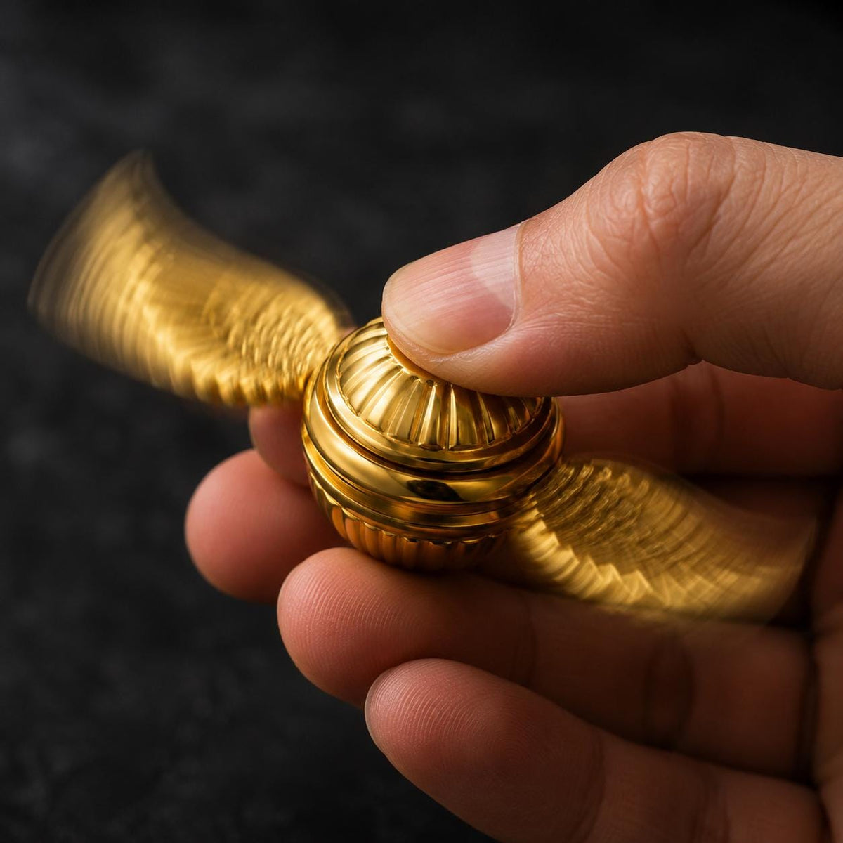 Spinner ailé en métal : doré en rotation entre les doigts
