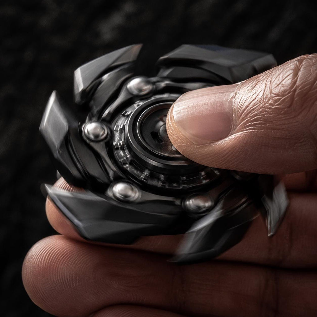 Spinner mécanique transformable : noir en rotation entre les doigts
