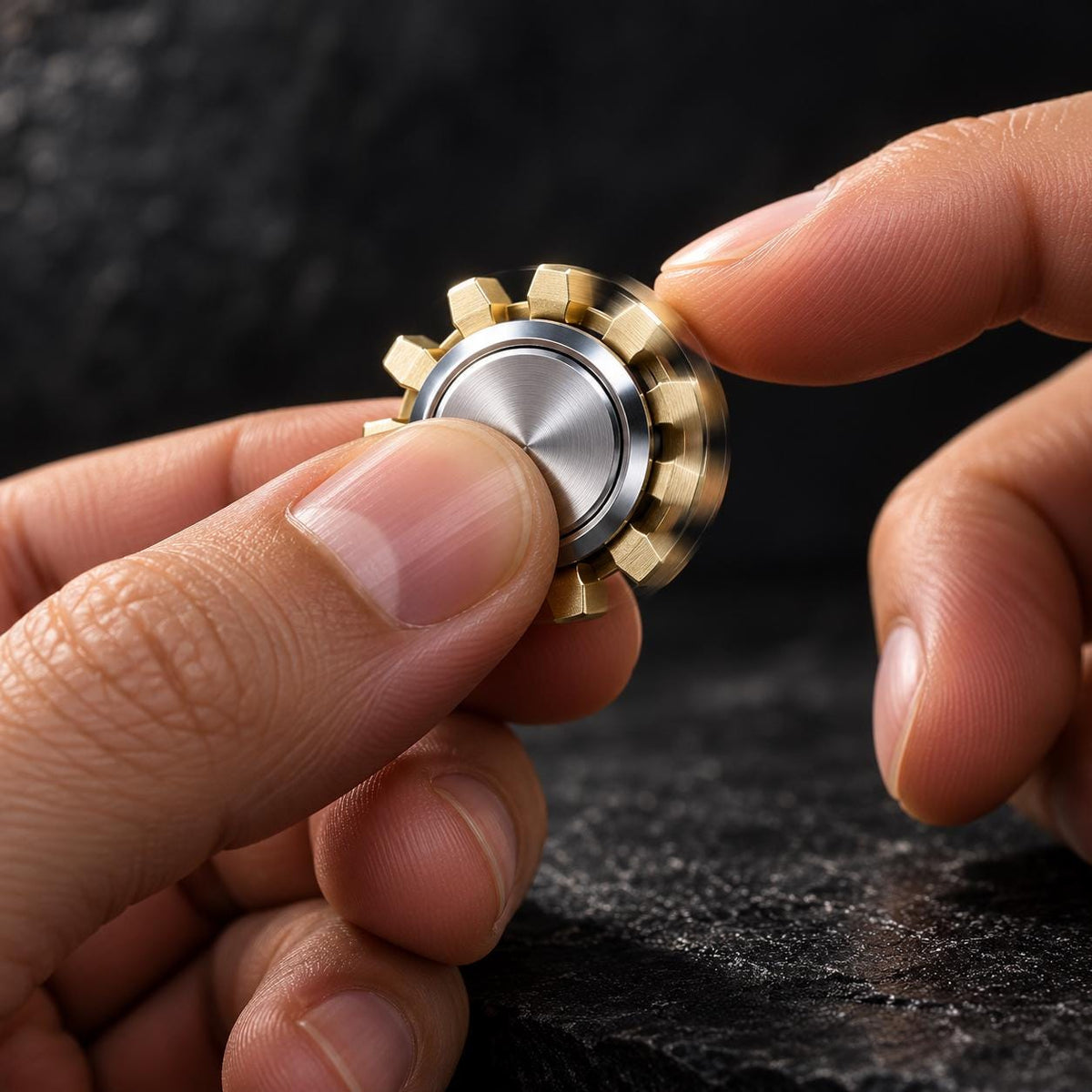 Mini spinner engrenage : dents dorées et centre argenté tenu en main